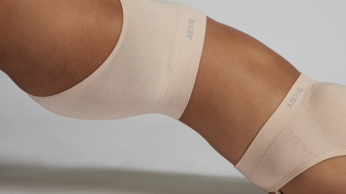 Close-up of a model wearing nude seamless underwear and a matching seamless bandeau-style bra, showcasing a smooth, minimalist fit against the skin.